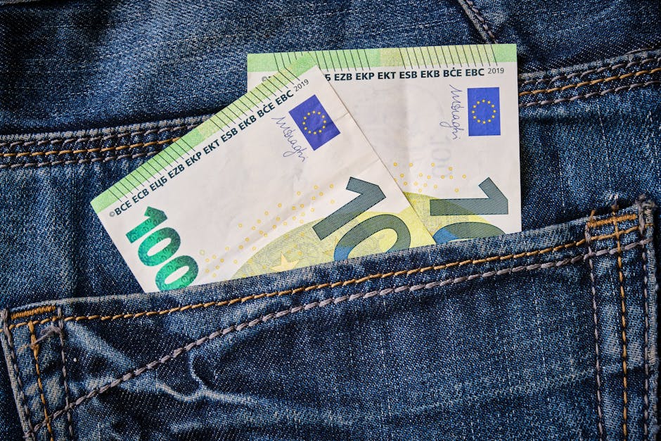 An overturned glass jar on a wooden floor spilling a mixture of euro banknotes and assorted coins, including 50 euro notes and various coins in copper and gold tones. The coins and notes are scattered across the surface, with some remaining inside the jar. The wooden floor features a natural grain pattern and appears clean and well-maintained. The scene highlights the importance of transparent and fair pricing practices in domestic and commercial cleaning services, as promoted by Kingston cleaners, to avoid hidden fees. Proper surface cleaning and equipment sanitation are implied to maintain hygiene and trust in professional cleaning services. The image has a neutral lighting setup, emphasizing the clarity of the money and the clean, textured surface of the floor.